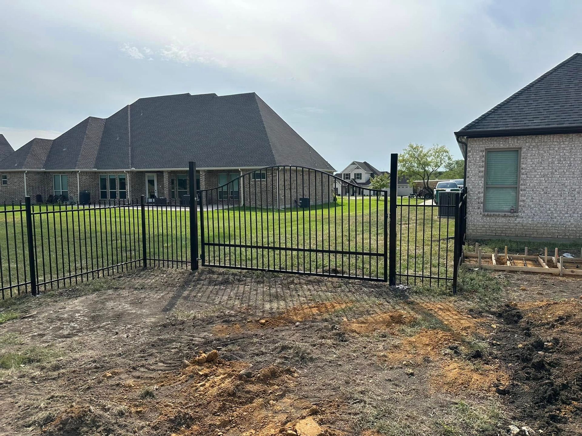 A fence with a gate in front of a house.