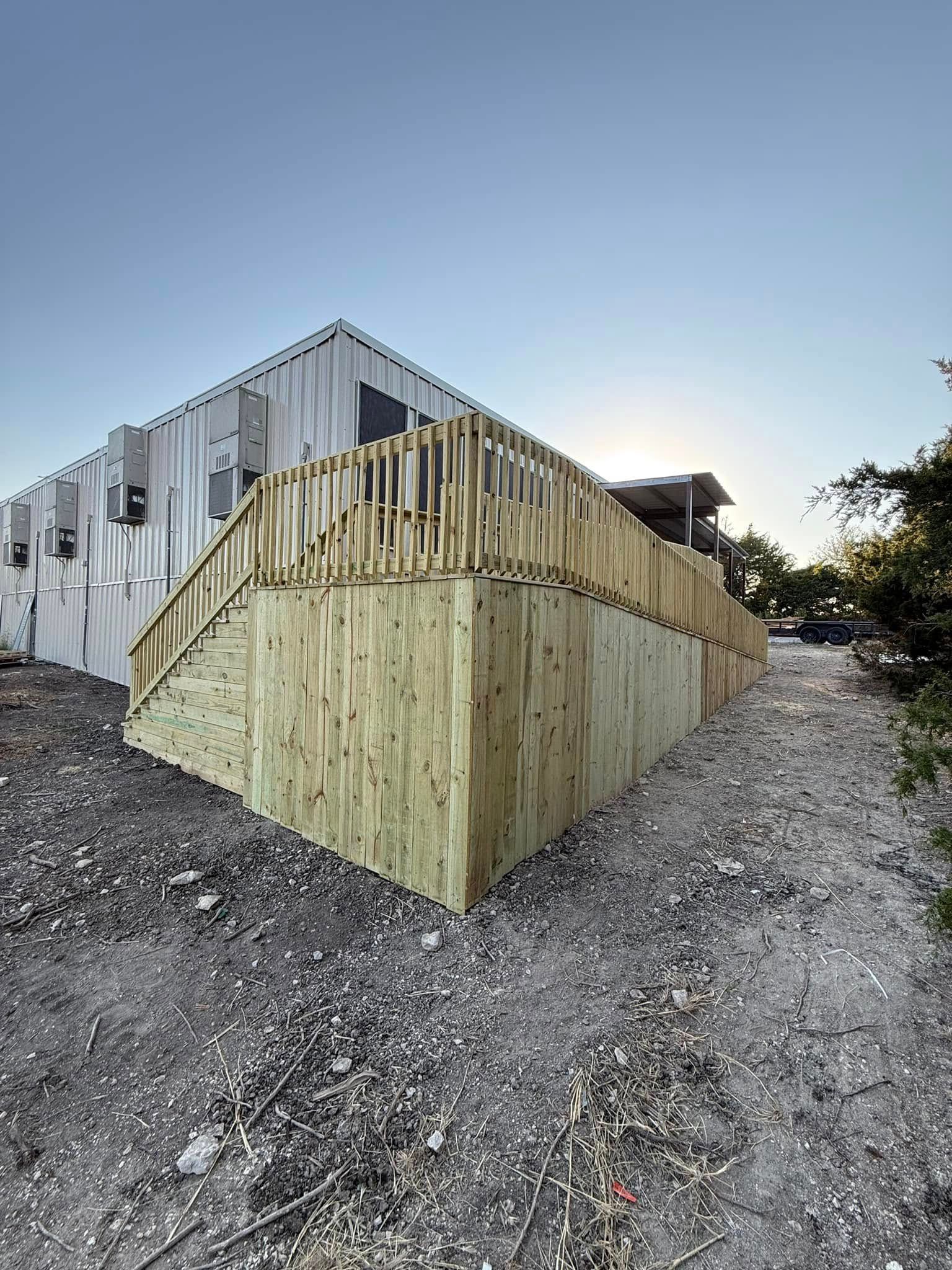 A house with a wooden deck and stairs on the side of it.