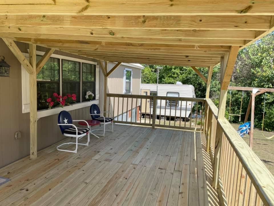 A wooden deck with chairs and a table on it.