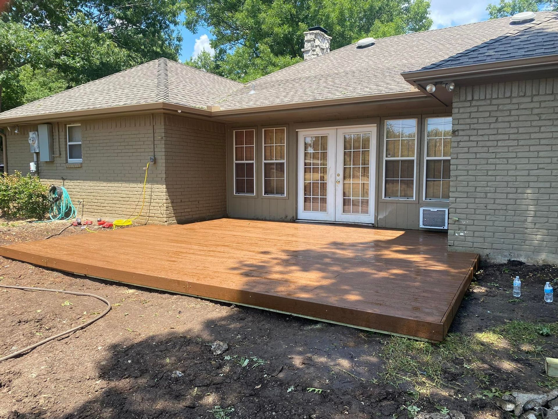 A large brick house with a wooden deck in front of it.
