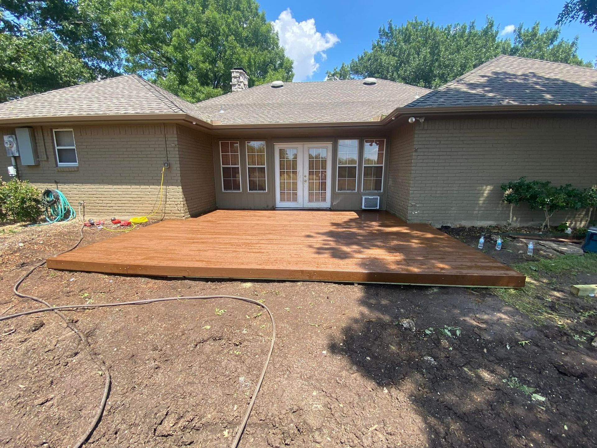 A large house with a wooden deck in front of it.