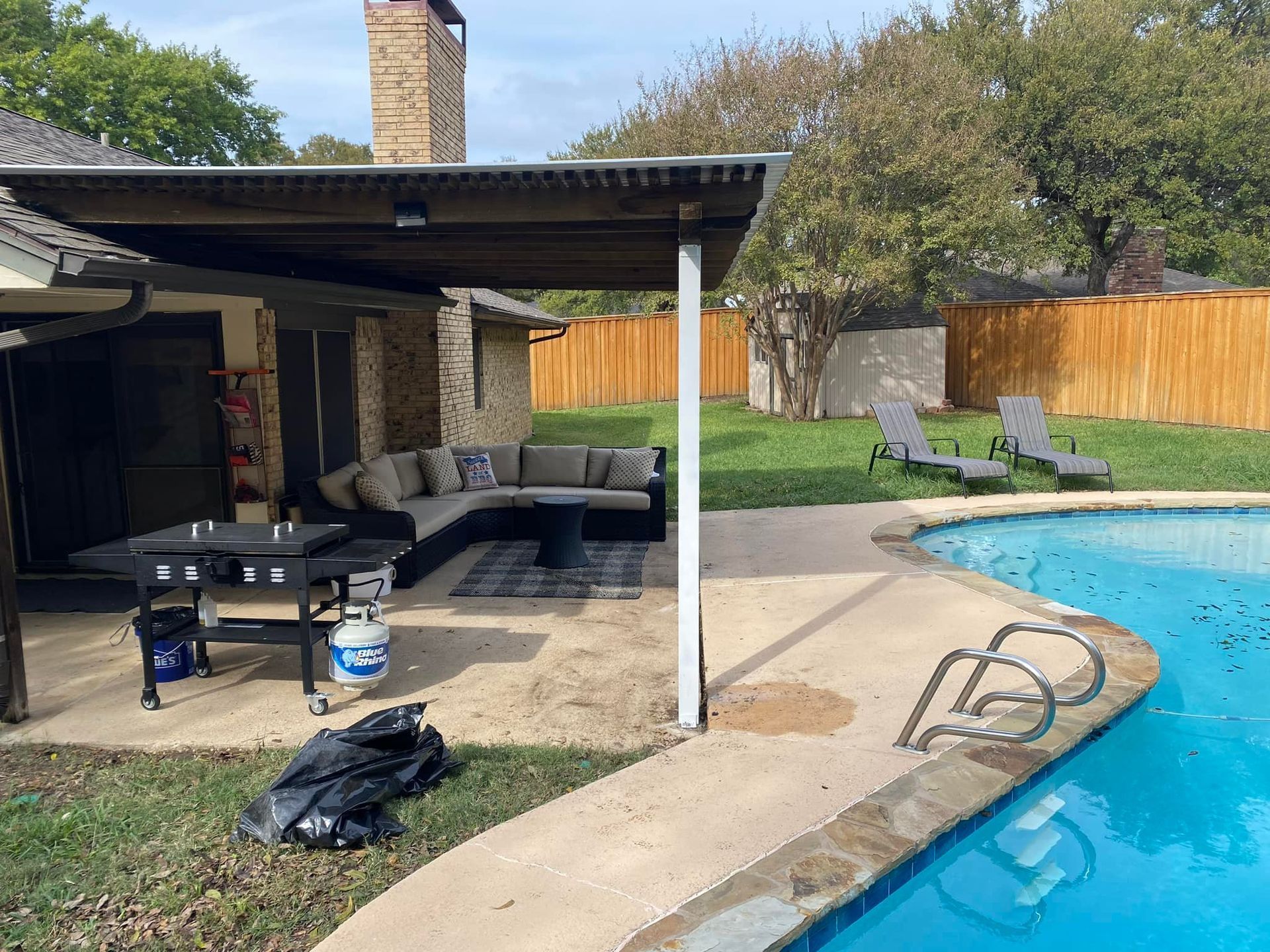 There is a swimming pool in the backyard of a house.