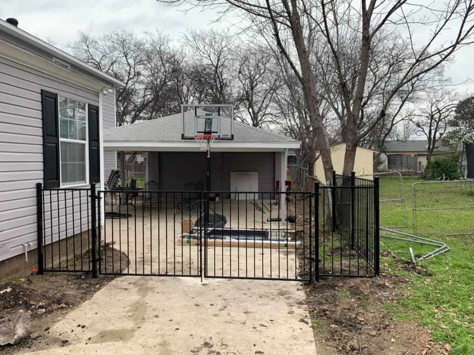 There is a basketball hoop in the backyard of a house.