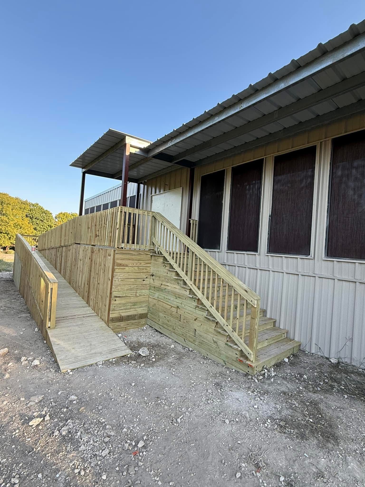 A wooden fence is surrounding a brick building.