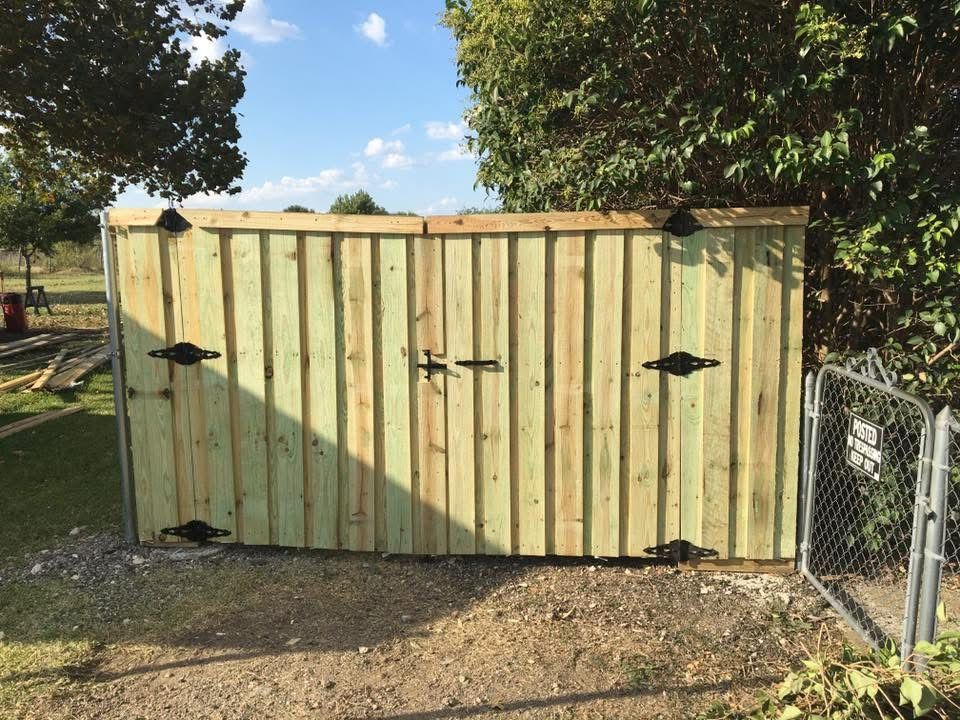 A wooden fence with a chain link fence behind it