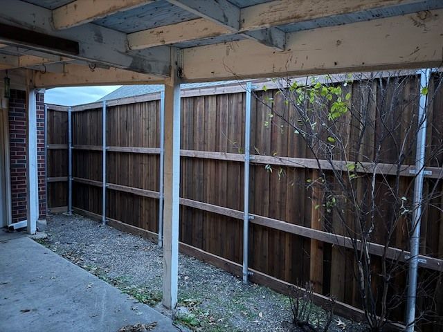 A wooden fence is surrounding a brick building.