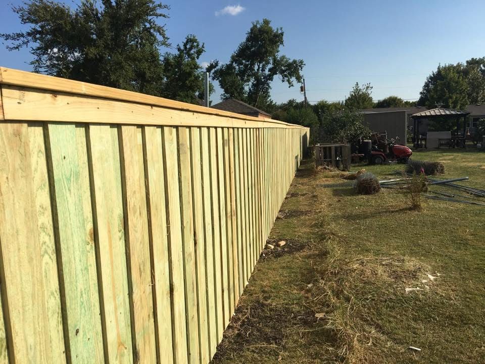 A wooden fence is sitting in the middle of a grassy field.