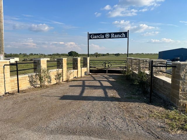 A sign for garcia ranch is above a gate
