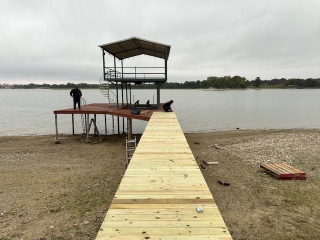 A wooden dock is being built on the shore of a lake.