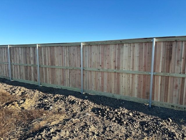 A wooden fence is sitting on top of a pile of dirt.
