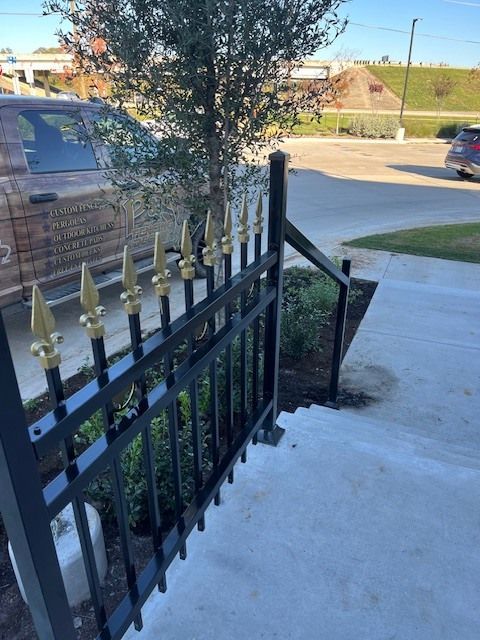 A black and gold fence with a car parked behind it