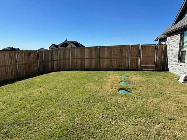 There is a wooden fence in the backyard of a house.