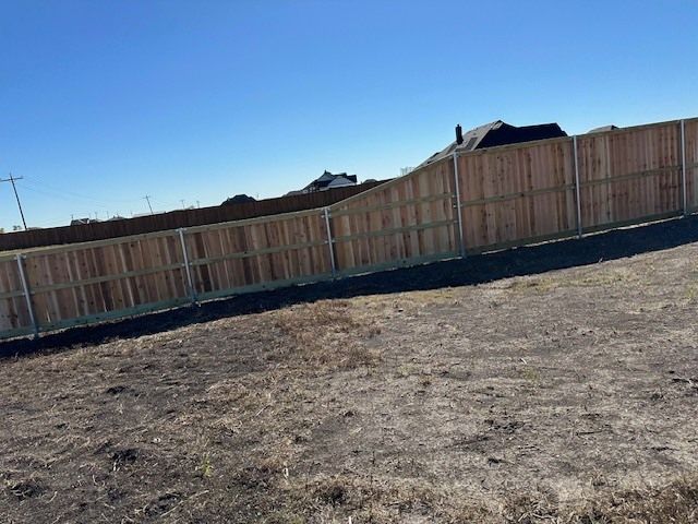 There is a wooden fence in the middle of a field.