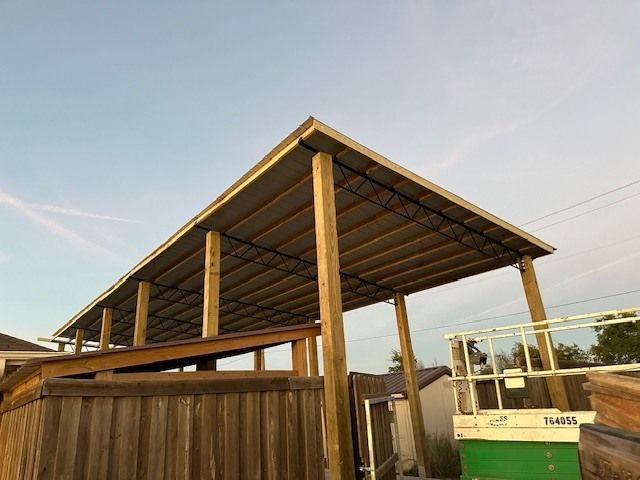 A wooden structure with a metal roof is being built