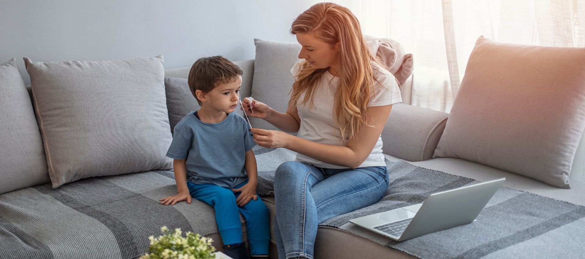 A woman is sitting on a couch with a child.