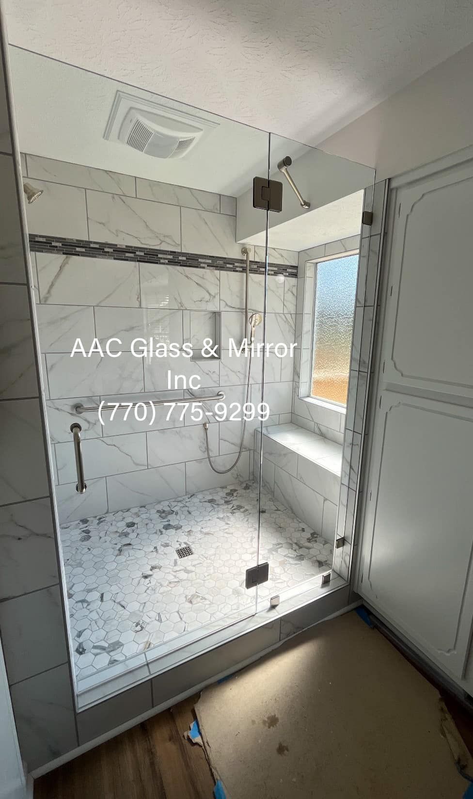 A bathroom with a walk in shower and a mirror.