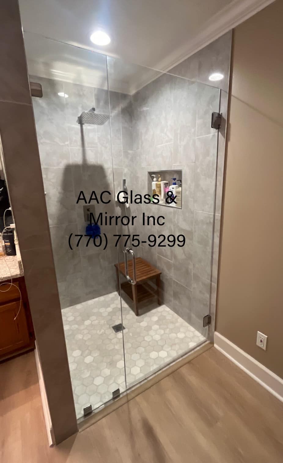 A bathroom with a walk in shower with a glass door.
