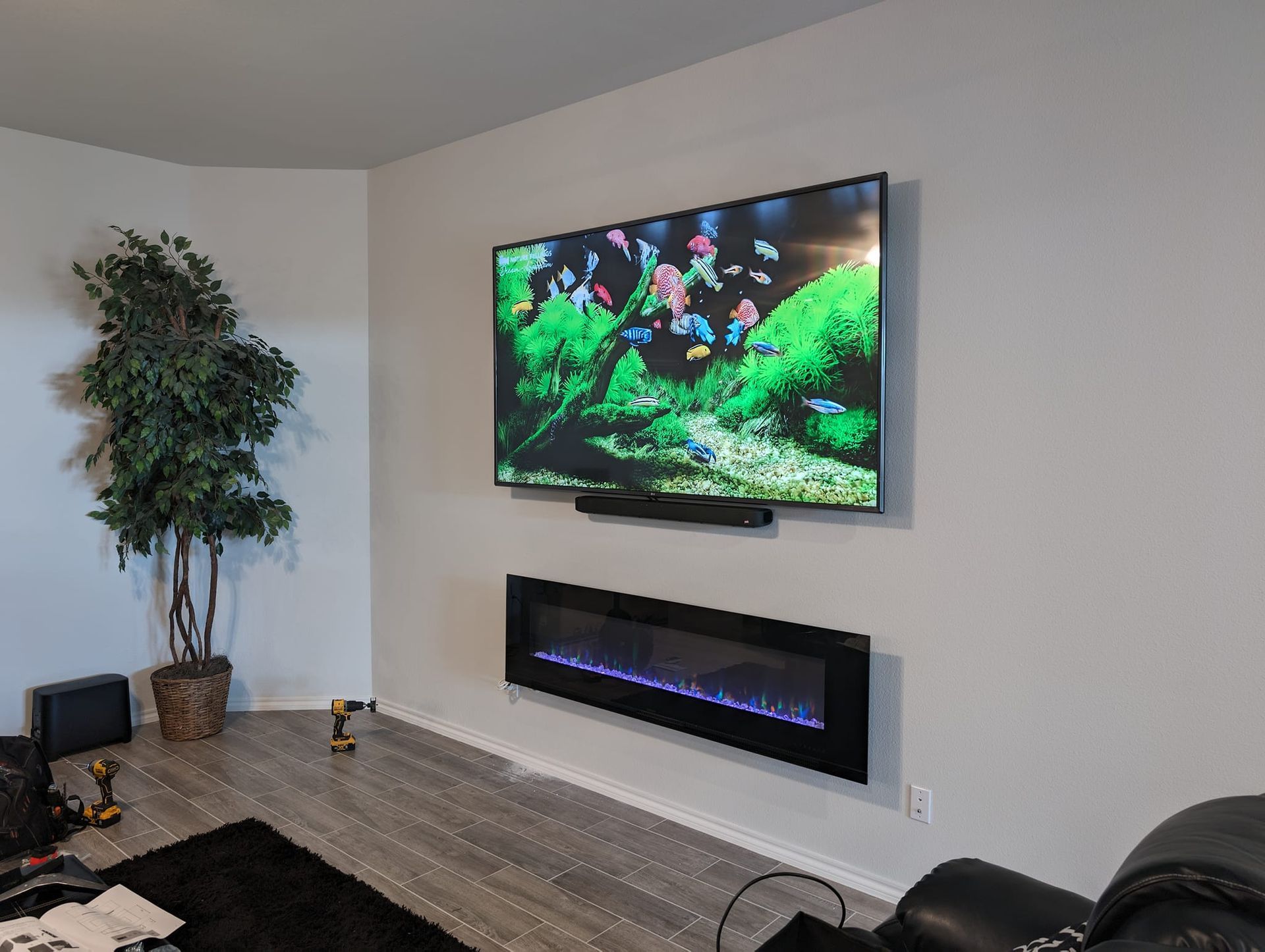 A living room with a fireplace and a flat screen tv on the wall.