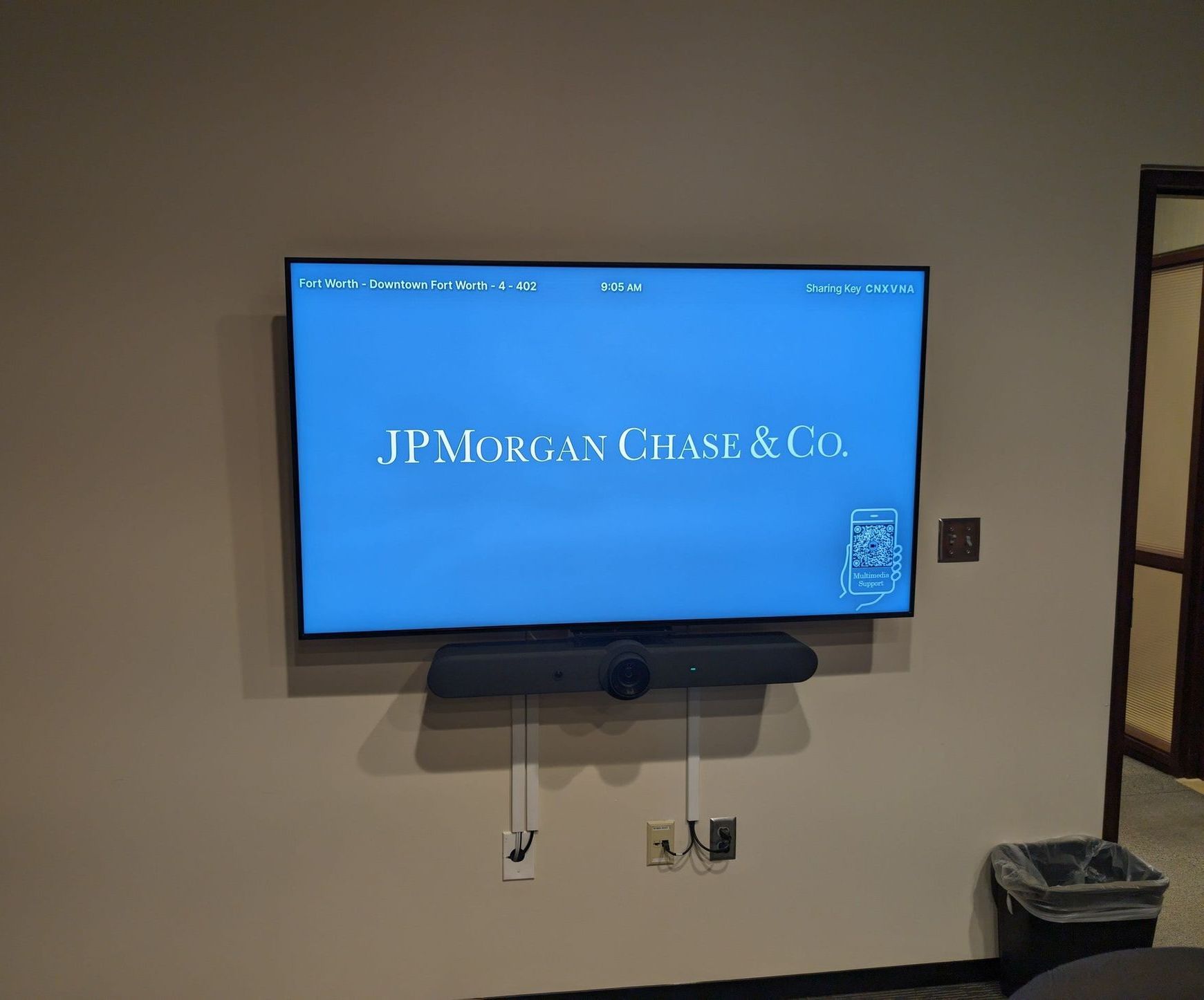 A flat screen tv is mounted on a wall and says jpmorgan chase & co.