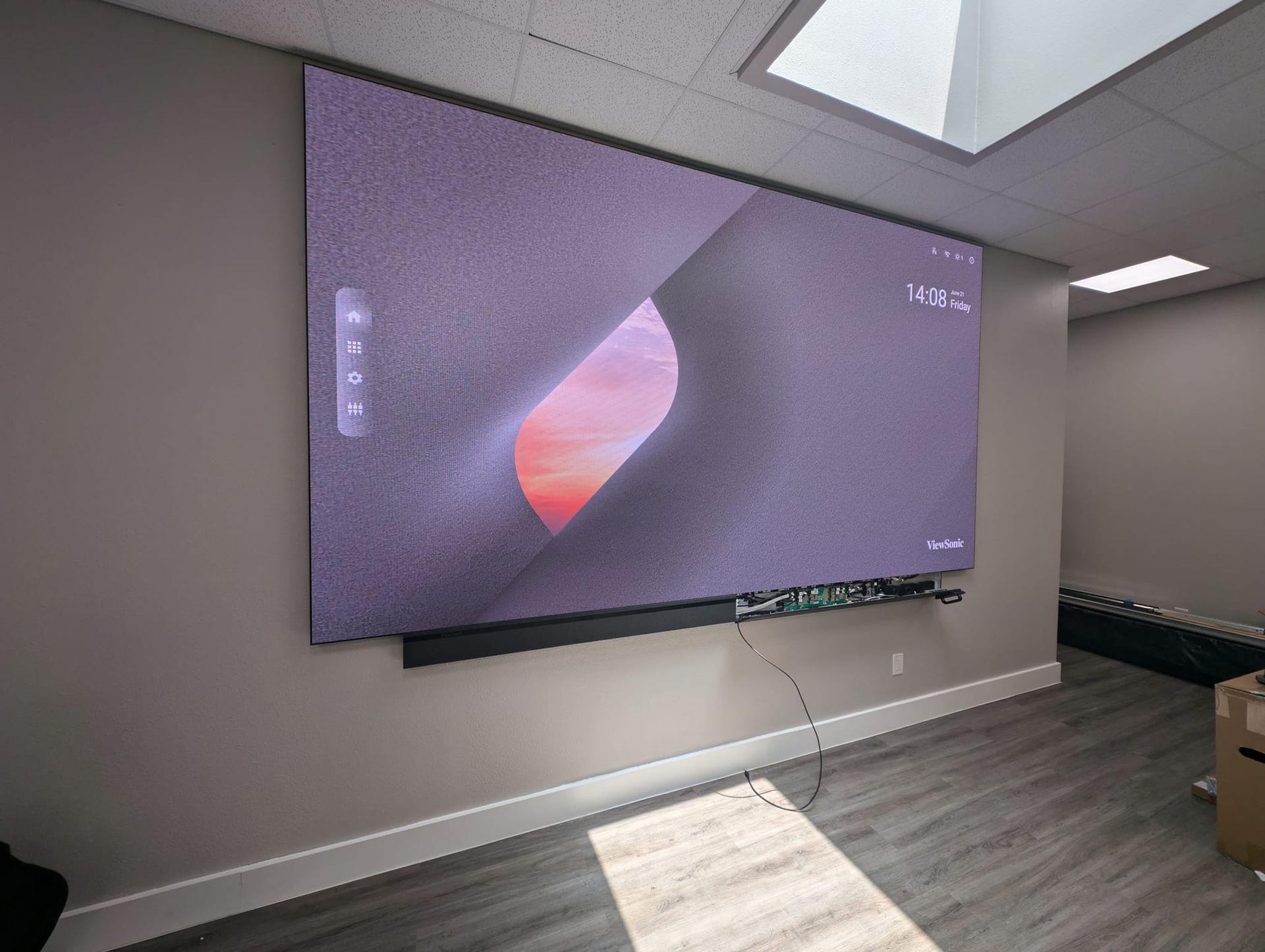 A large screen is hanging on a wall in a room.