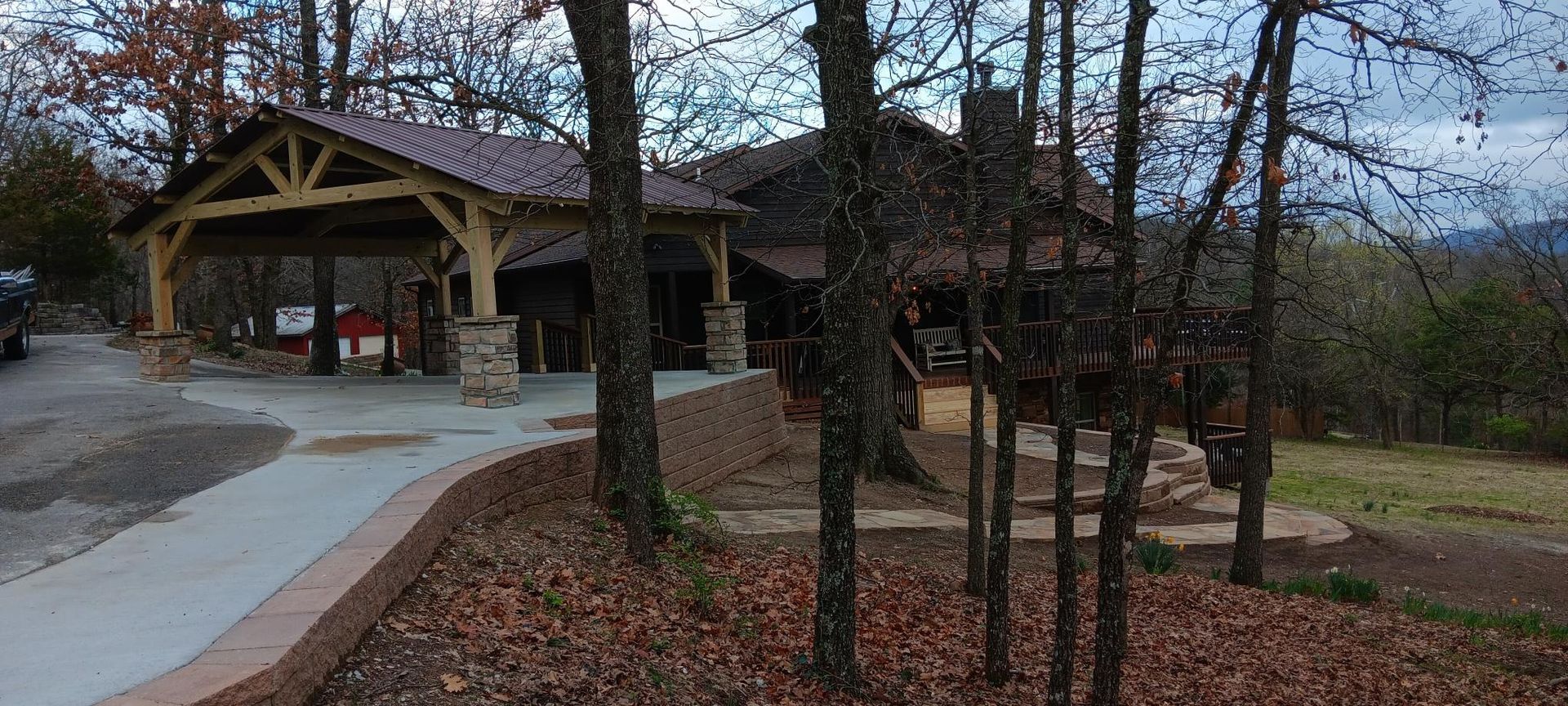 A rustic lodge with a covered pavilion and a surrounding wooded area. Brown and gray hues dominate the scene.