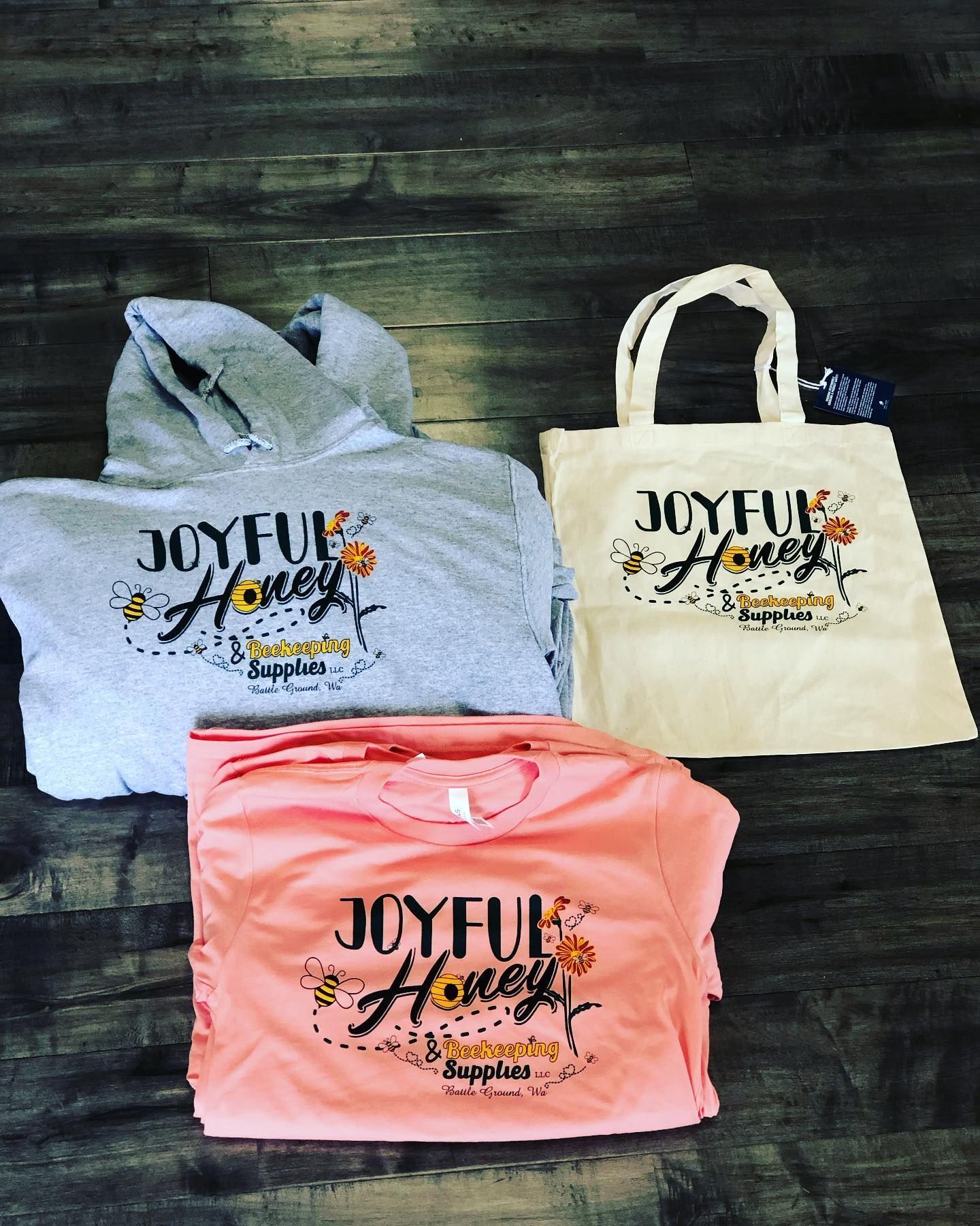 Gray hoodie, peach t-shirt, and white tote bag with