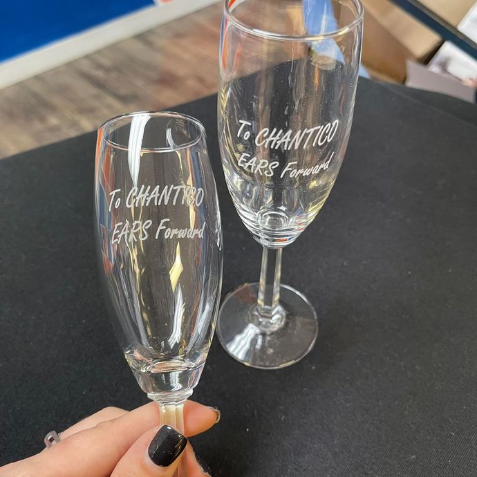 A person is holding two champagne glasses that say to chantred years forward