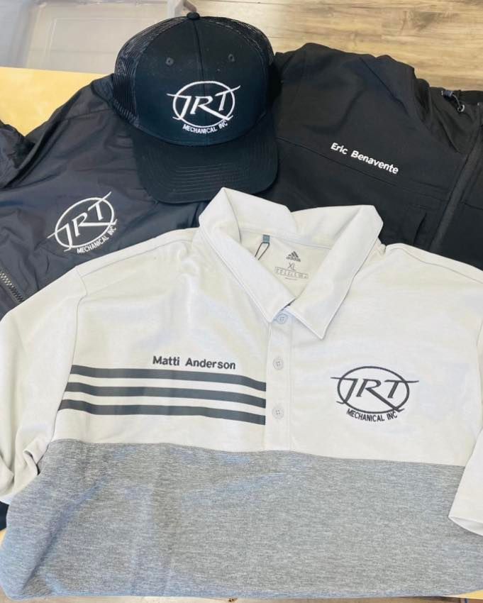 A group of shirts and hats are sitting on top of each other on a table.