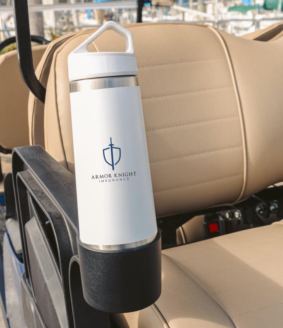 A white water bottle is sitting on the back seat of a golf cart