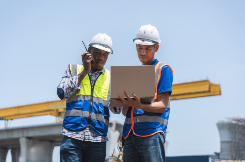 Wooden blocks arranged as a house and trees on a blueprint, promoting Sustainability Manager jobs.