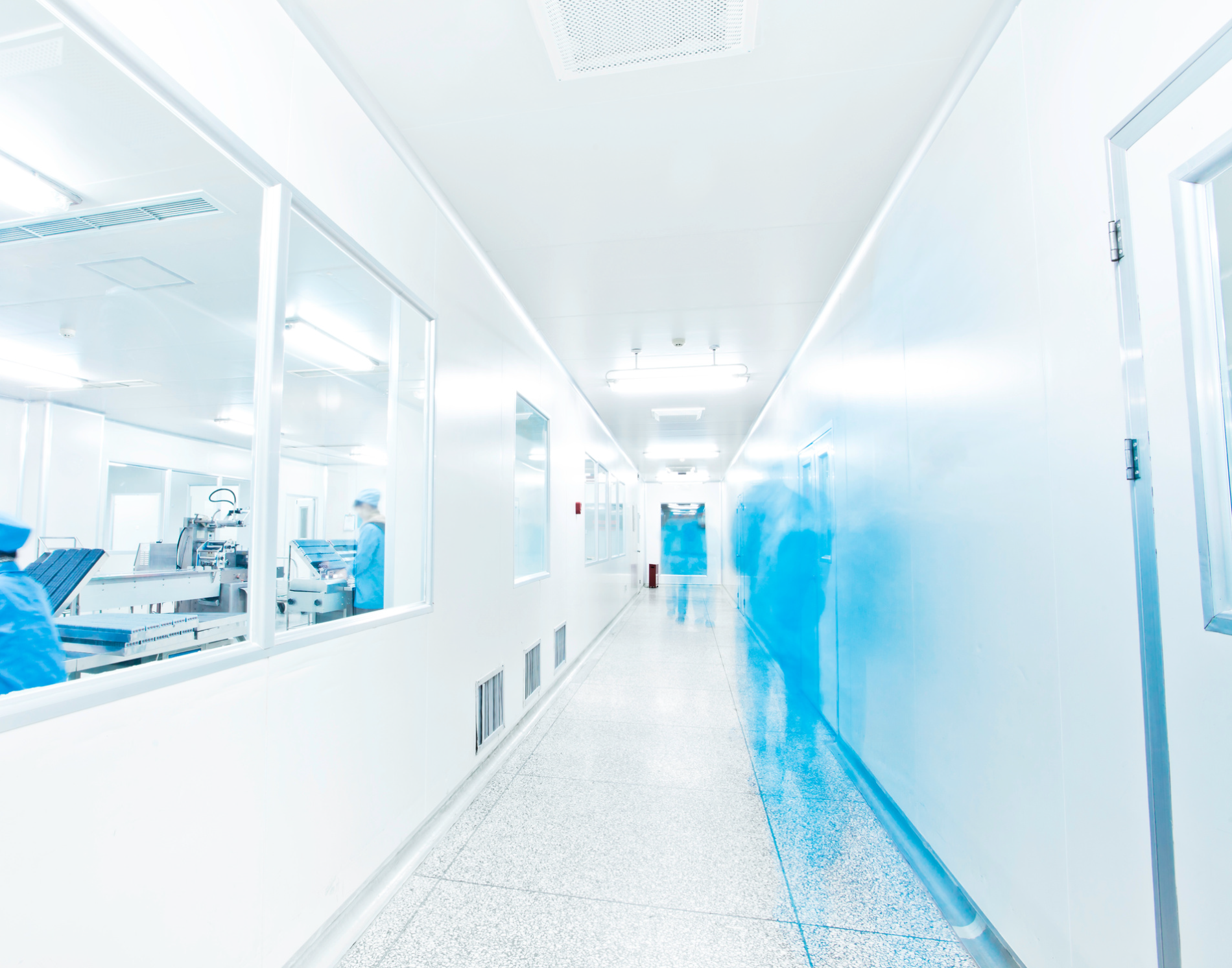 Bright white lab hallway with blurred figures walking toward the exit.
