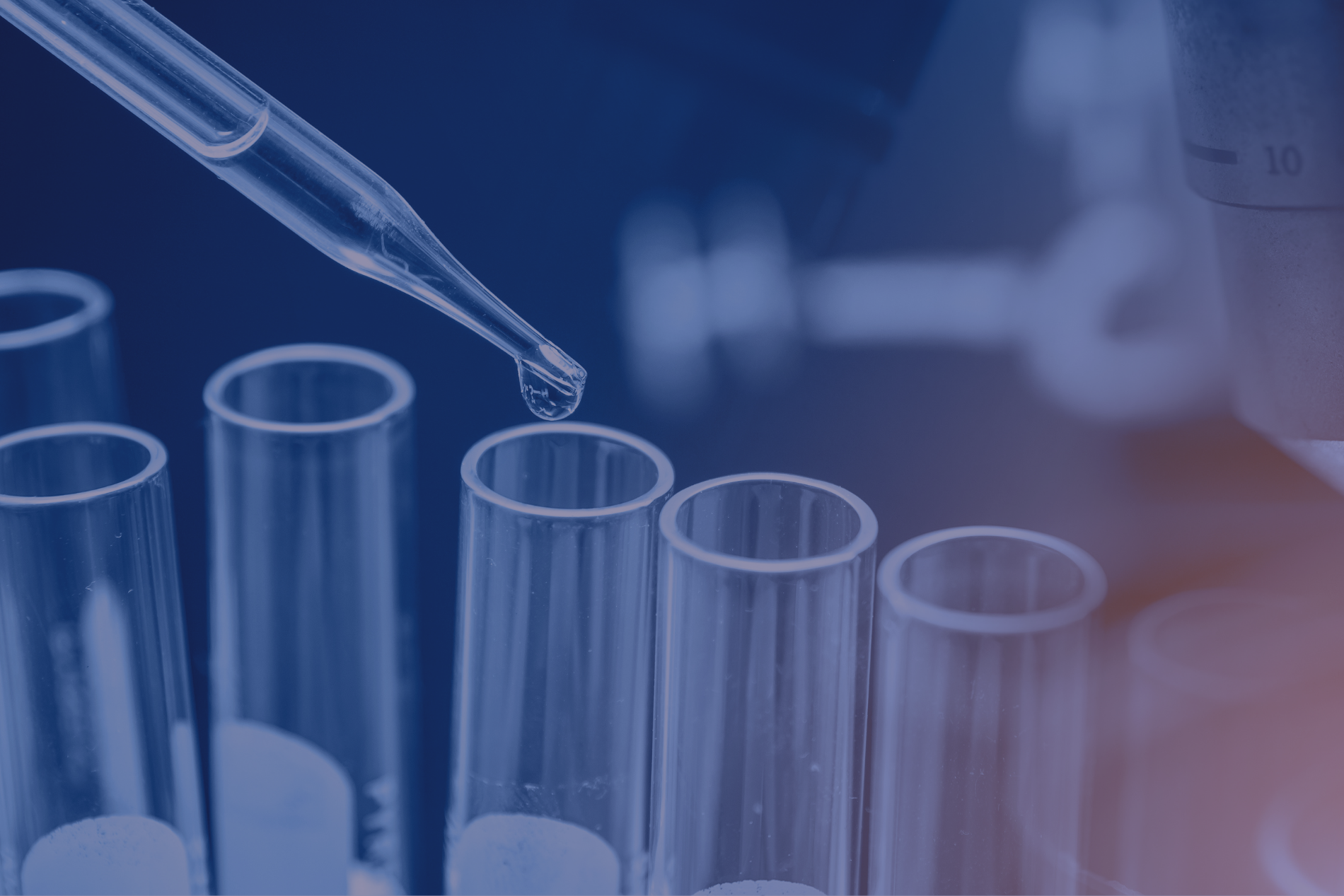 Dropper dispensing liquid into a test tube, with other tubes in view, in a lab setting.