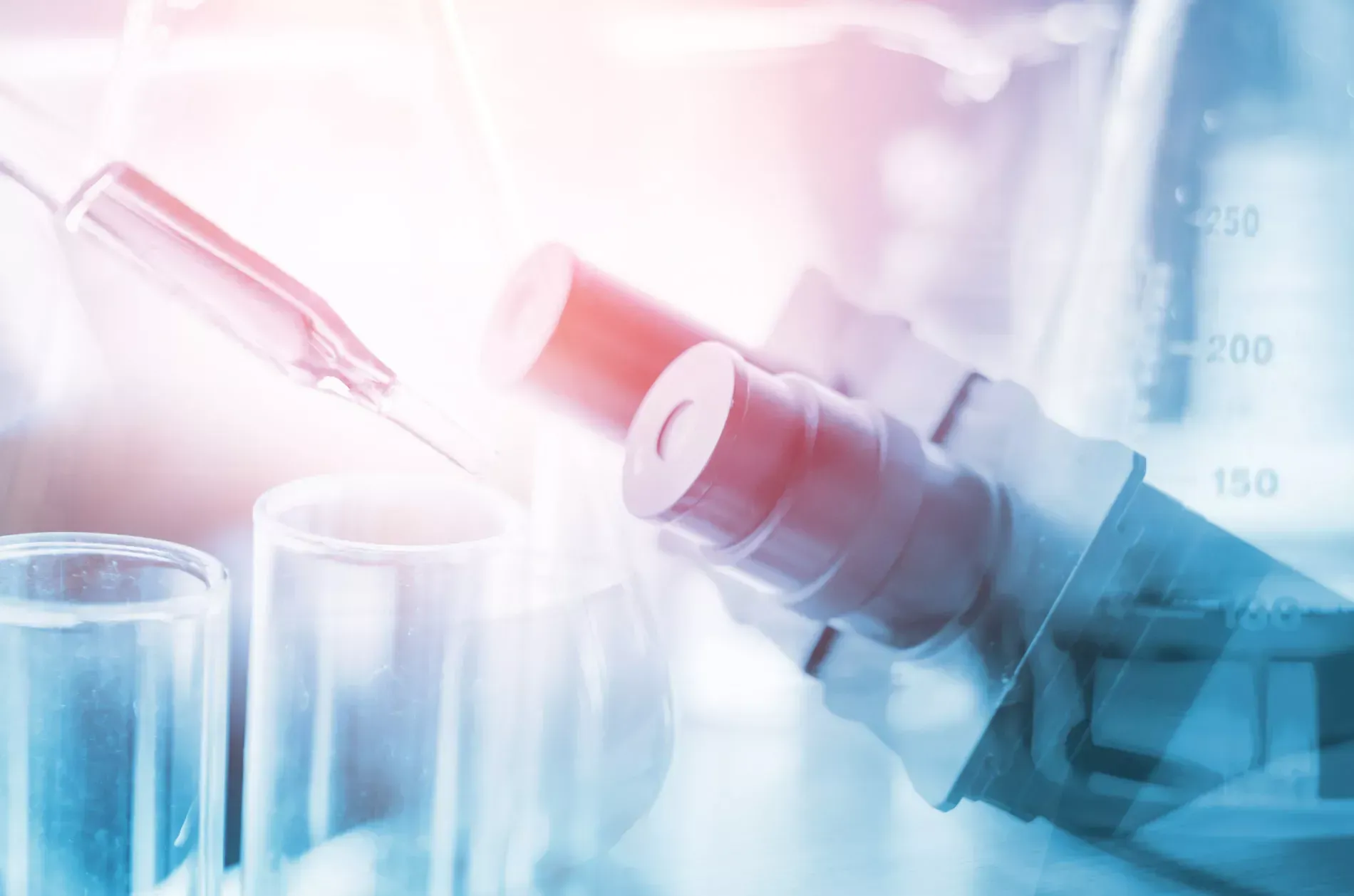 Microscope with beakers, pipette, and laboratory equipment in a bright, blue and red-toned setting.