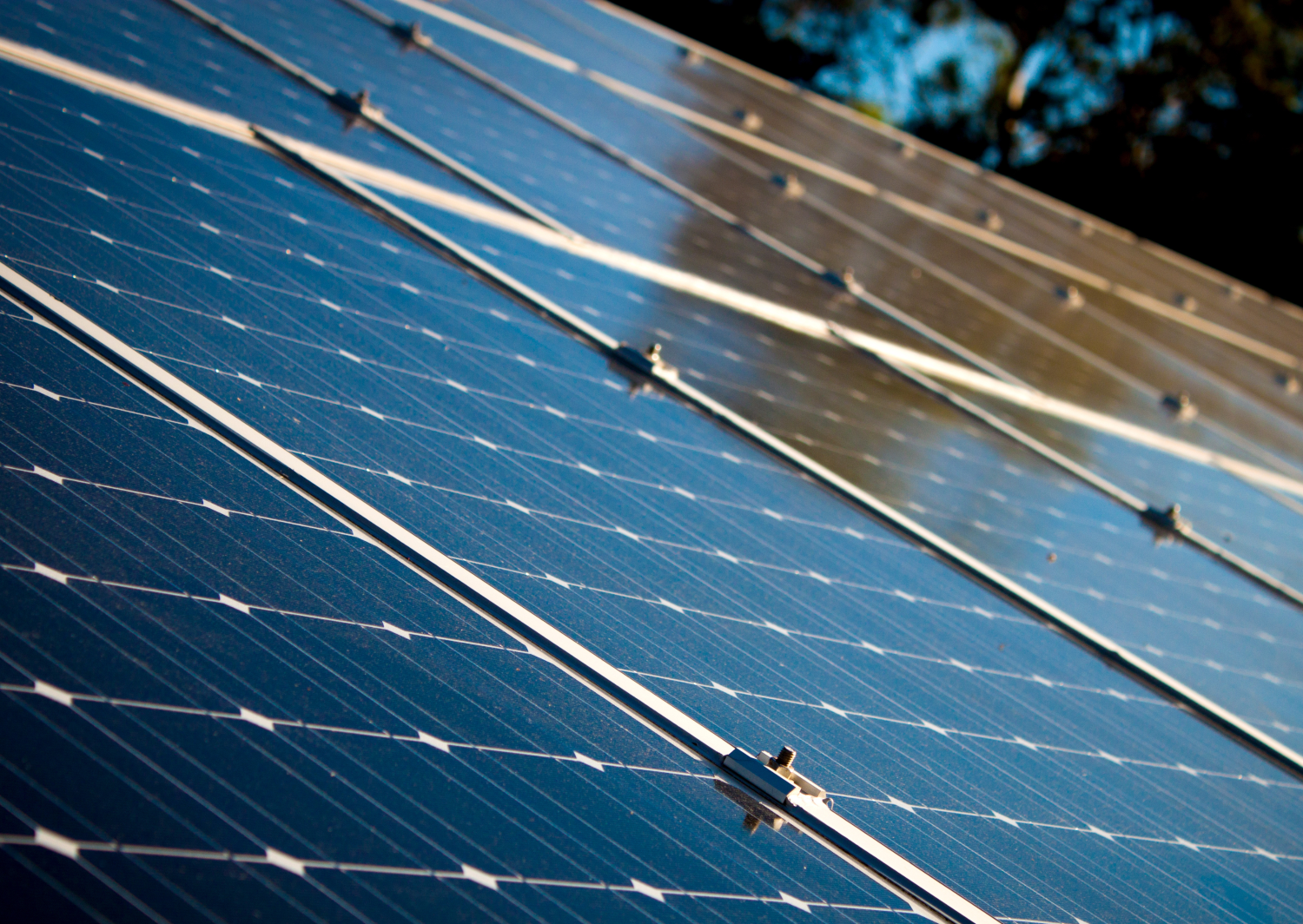 Solar panels on a roof, reflecting sunlight.