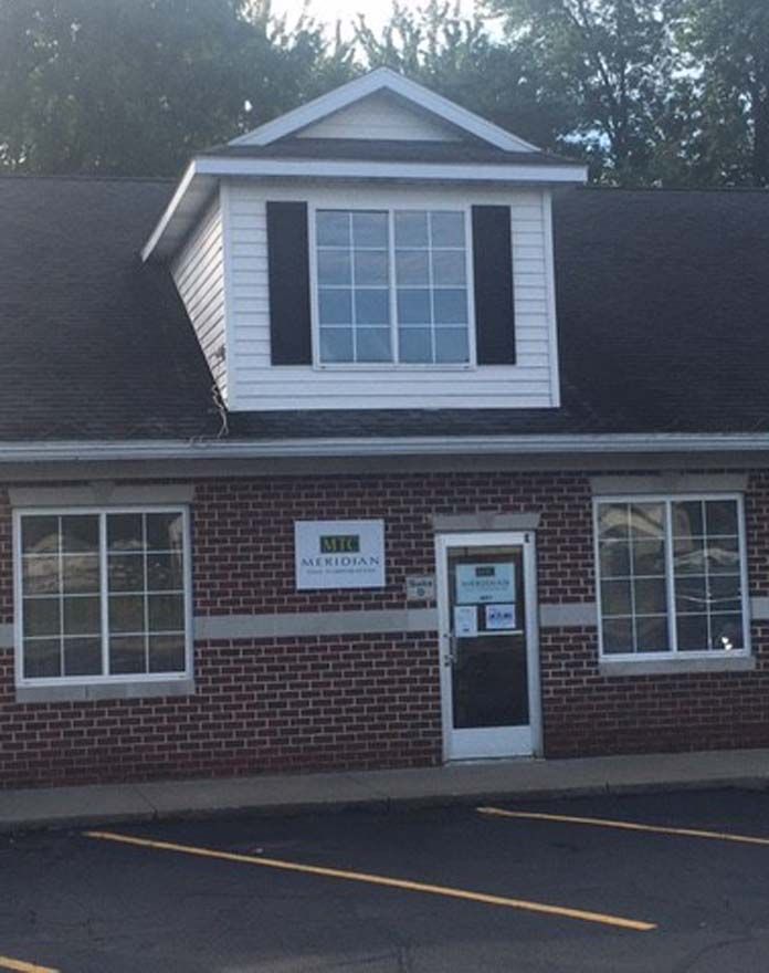 A brick building with a white roof and a sign that says ' liberty ' on it