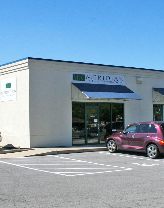 A purple car is parked in front of the meridian building