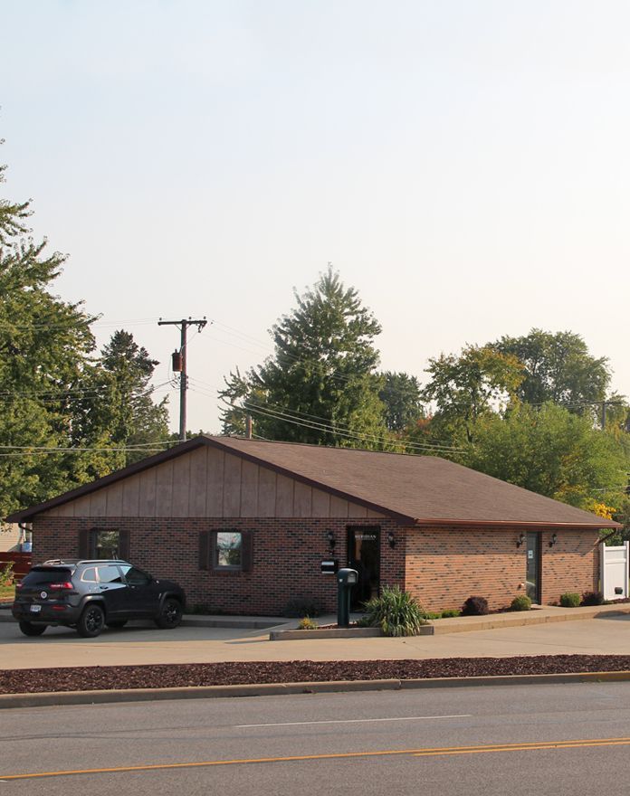 A brick building with a car parked in front of it