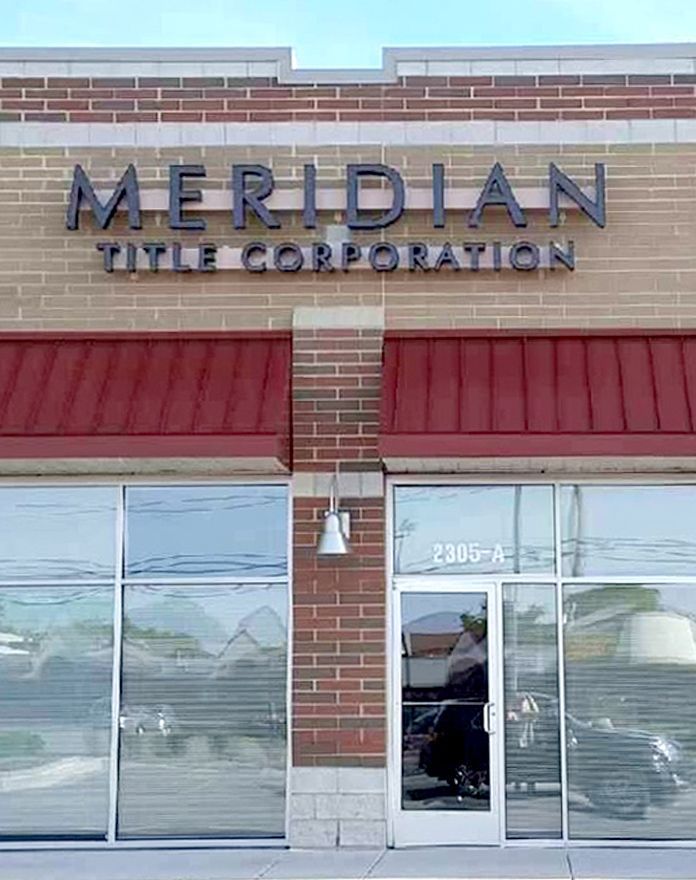 The front of a brick building with a sign that says meridian title corporation.