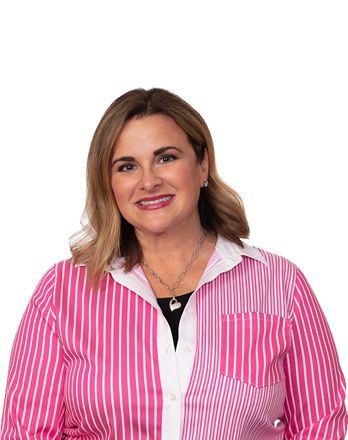 A woman is wearing a pink and white striped shirt and smiling.