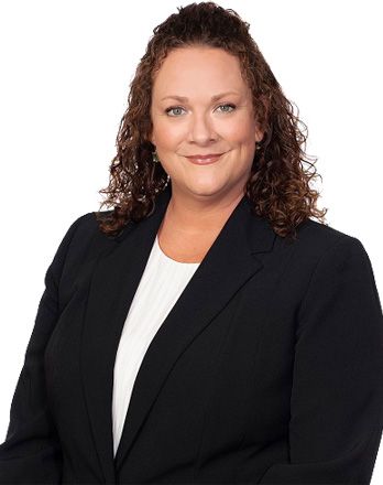 A woman with curly hair is wearing a black jacket and white shirt.