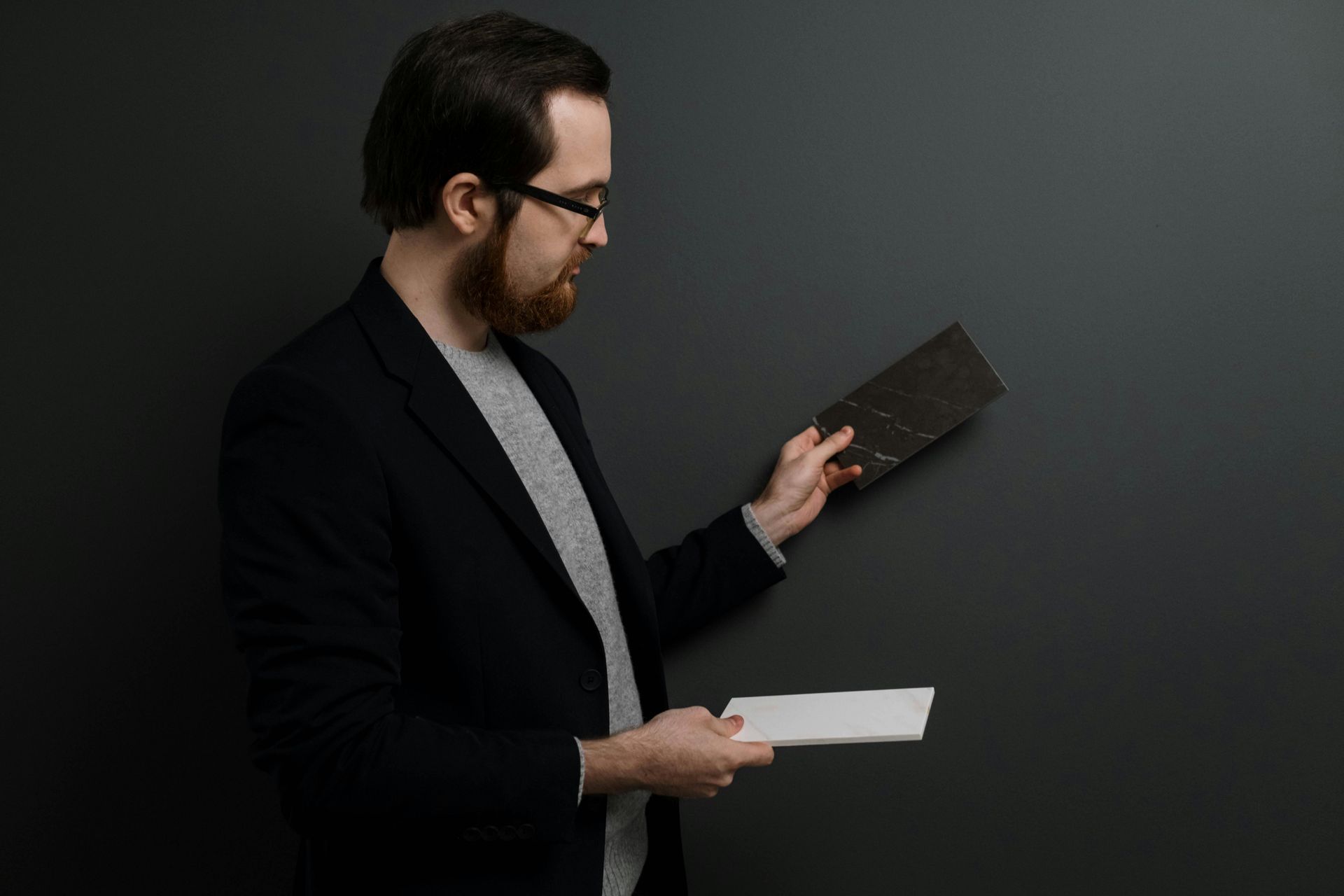 Two men are standing in an empty room with their hands on their hips.