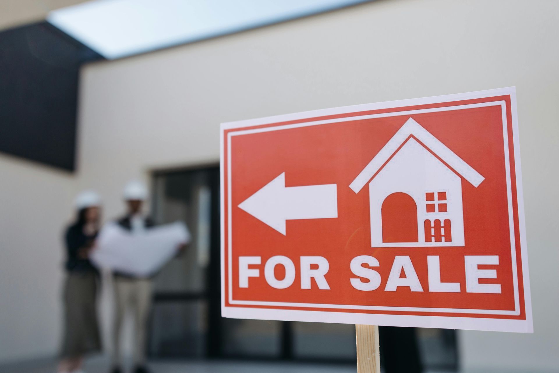 A for sale sign is in front of a house.