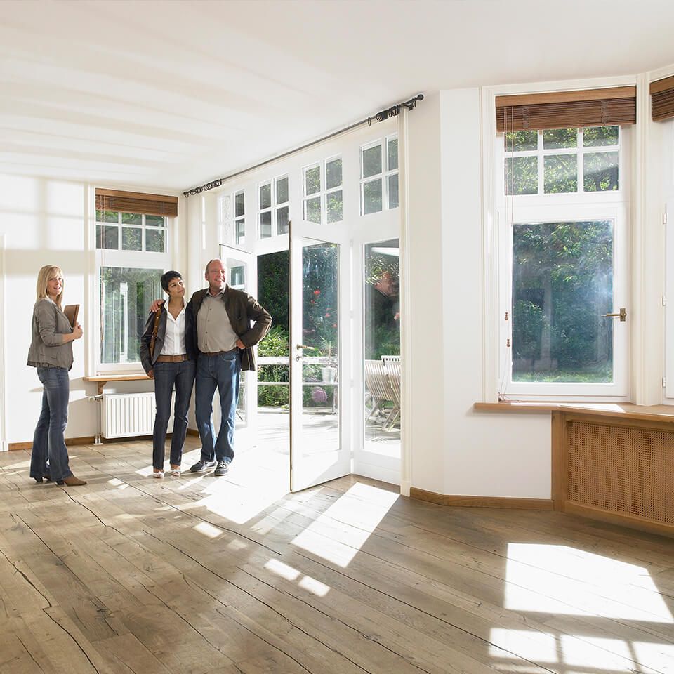 A group of people are standing in an empty room