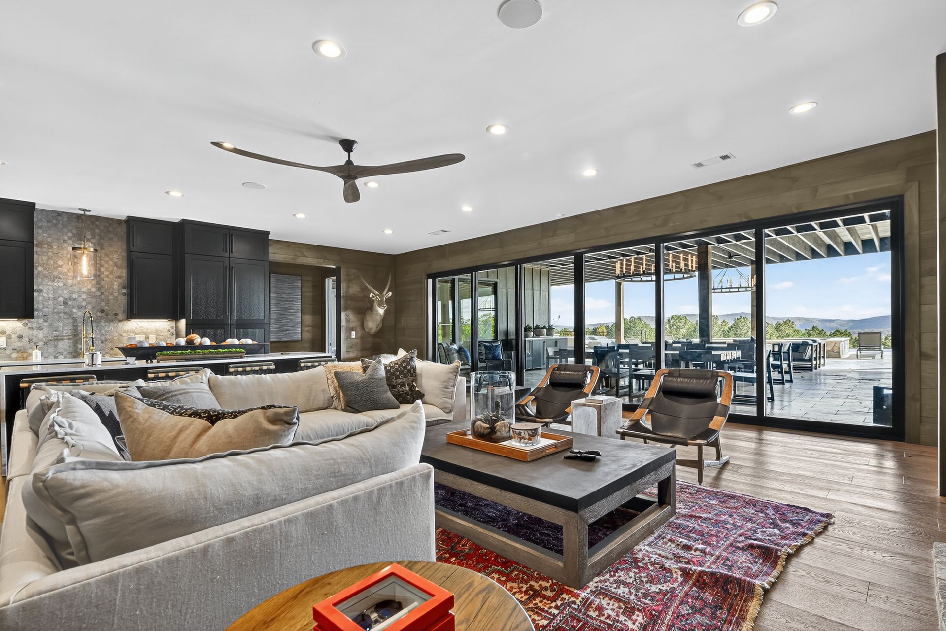Spacious living room with a large sofa, sliding glass doors, and a view of an outdoor patio.