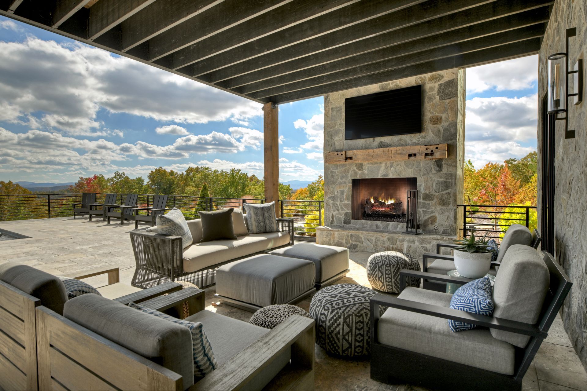 Outdoor patio with fireplace, seating, and scenic view.