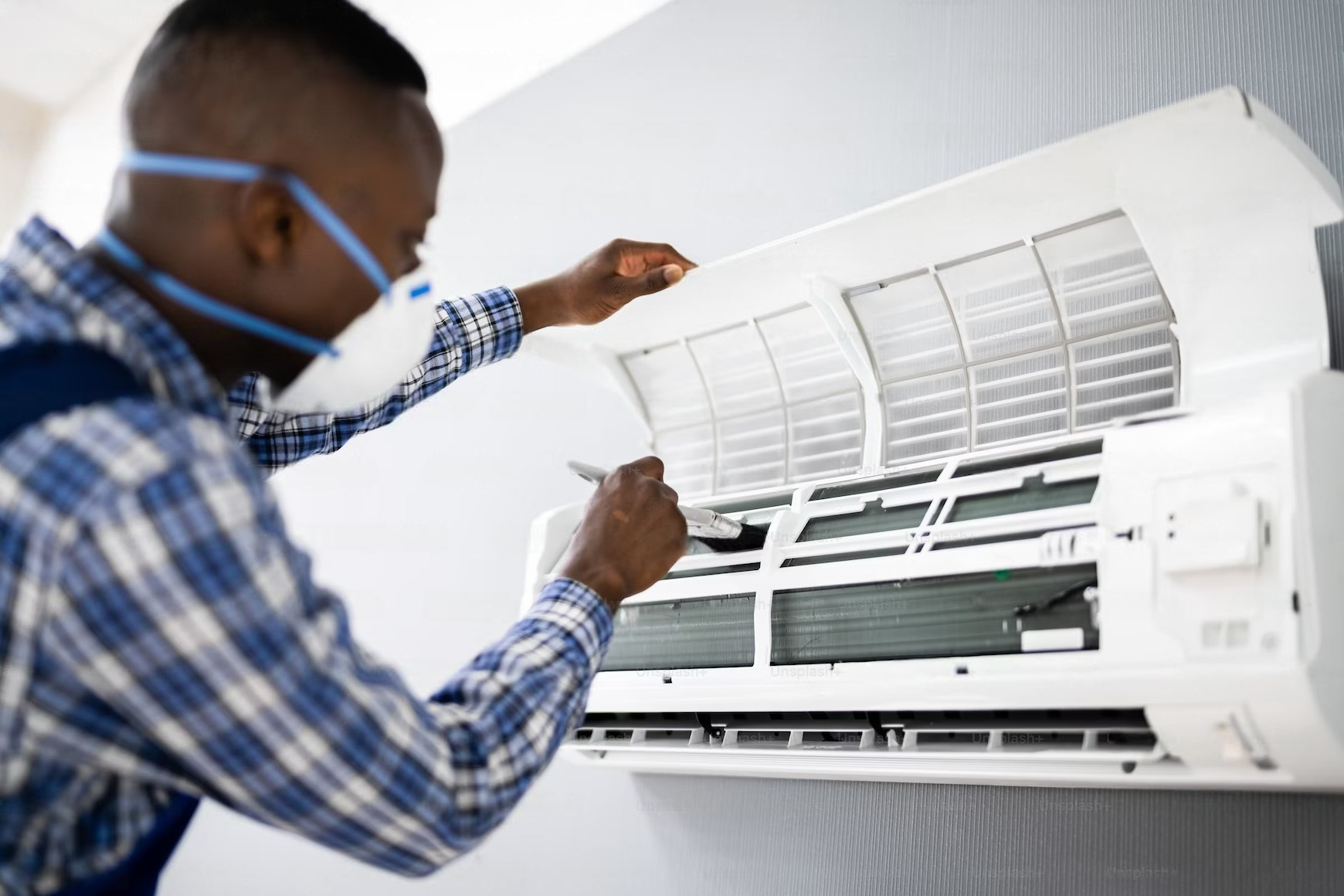 Professional technician performing routine maintenance and cleaning on an air conditioner to ensure optimal performance and efficiency.