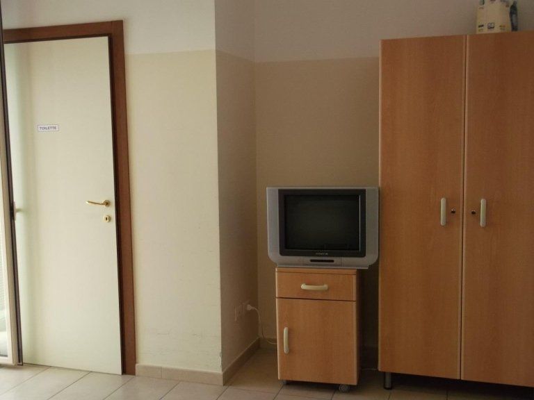 camera di una casa di riposo con armadio e tv