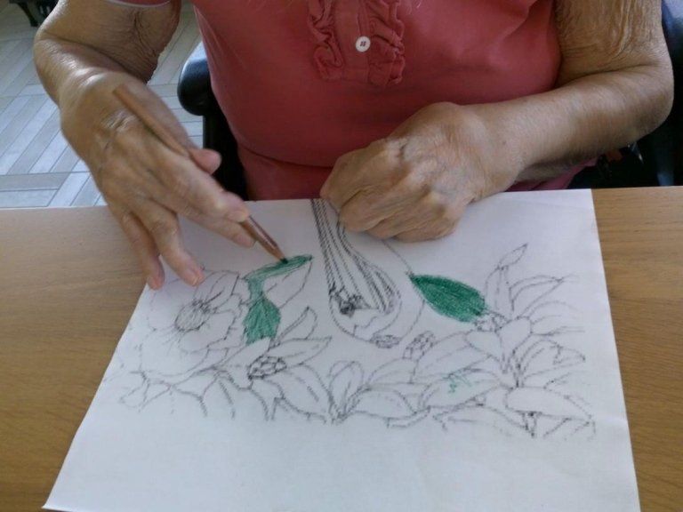 anziana che colora un disegno