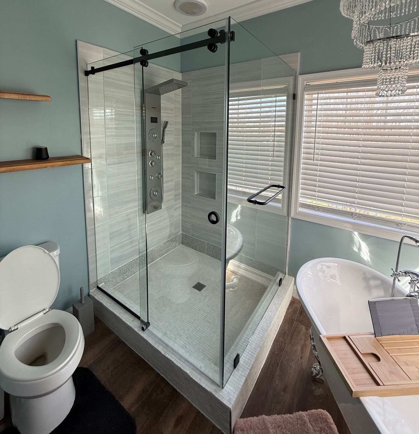 A bathroom with a toilet , tub , shower and window.