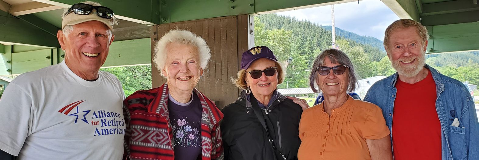 a group of people are posing for a picture under a bridge .
